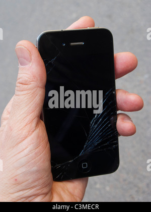 Verre fissuré d'un iPhone 4 dans la paume de la main Banque D'Images