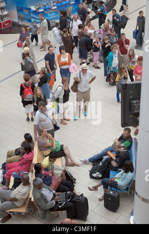 Les passagers en attente d'information de vol au départ de l'aérogare sud à l'aéroport de Gatwick, Angleterre Banque D'Images