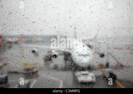 Avions à travers gouttes de pluie sur la fenêtre Banque D'Images