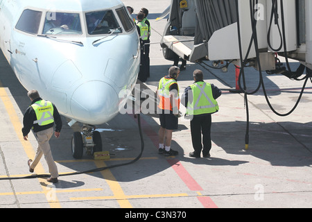 Les hommes qui travaillent sur un avion pour se préparer pour le départ Banque D'Images