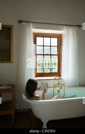 L'Afrique du Sud, Western Cape, Calitzdorp, Red Mountain. Femme en baignoire, livre de lecture. Banque D'Images