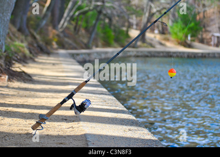 Canne à pêche avec un flotteur près du lac. Banque D'Images