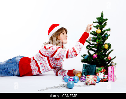 Belle Femme au chapeau de noël décore un arbre de Noël Banque D'Images