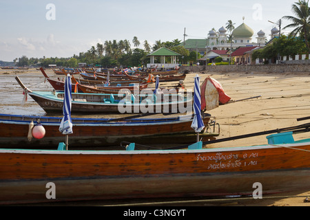 Longue queue des bateaux sur la plage à la baie de Chalong avec le Aowalul Hidayah mosquée dans l'arrière-plan, Phuket Thailand Banque D'Images