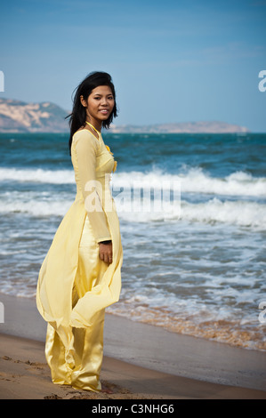 Young Asian Woman in yellow ao dai sur la plage Banque D'Images