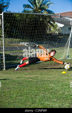 Gardien d'une équipe de football U13 de l'enregistrement d'un ballon Cape Town Afrique du Sud Banque D'Images