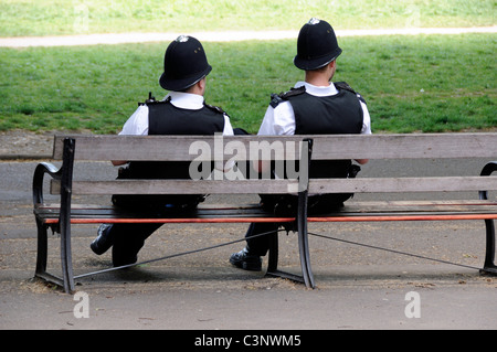 Bobbies assis sur un banc, deux agents de la police métropolitaine sur des activités d'été dans les champs de Highbury London England UK Banque D'Images