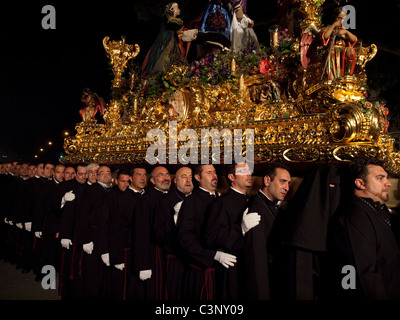 Costaleros portant un flotteur religieux (connu comme un Trono) dans les processions de la Semana Santa à Málaga, Avril 2011 Banque D'Images