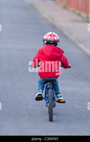 Un garçon de trois ans équitation son vélo le premier jour sans stabilisateurs dans l'Uk