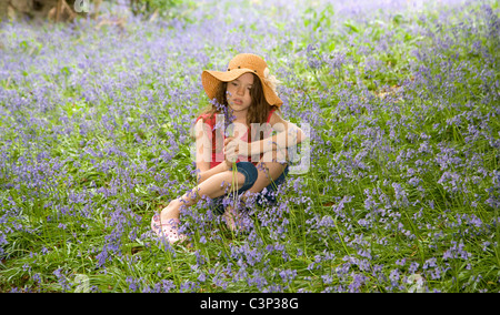 Une fille assise à Bluebells Banque D'Images