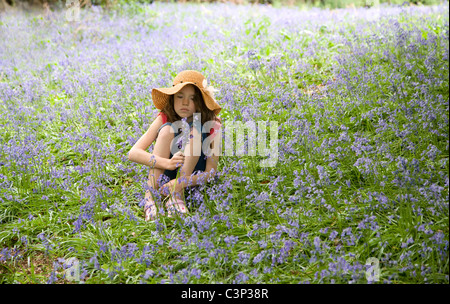 Une fille assise à Bluebells Banque D'Images