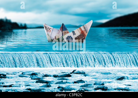 Bateau Origami papier des billets sur waterfall Banque D'Images