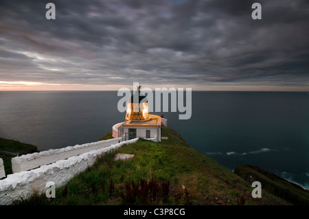 Au début de la nuit et le phare de St Abbs Head sur la côte sud-est de l'Ecosse. Banque D'Images