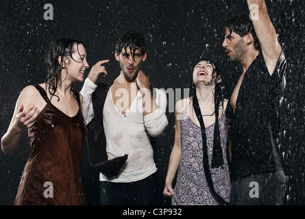 Bénéficiant d'amis dans la pluie, le sourire. Banque D'Images