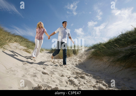 Allemagne, Schleswig Holstein, Amrum, Couple d'exécution dans les dunes de sable Banque D'Images