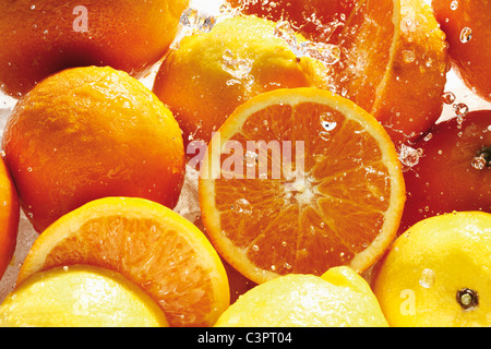 Les éclaboussures d'eau sur les oranges et citrons Banque D'Images
