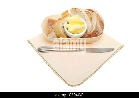 Pain et beurre dans un panier de bois avec un couteau sur une serviette Banque D'Images