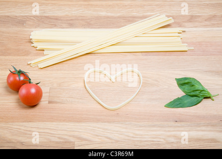 Forme de coeur et les pâtes, les tomates, le Basilic Banque D'Images