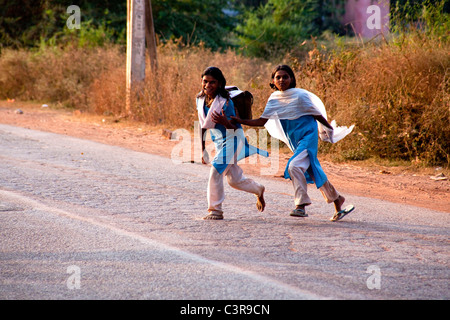 Les jeunes élèves de l'école des femmes en marche et traverser la rue, les filles sur la route Khajuraho-Varanasi, Inde, Asie Banque D'Images