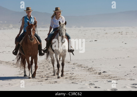 2 Les gens de l'équitation sur la plage Banque D'Images