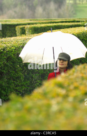 Femme avec parapluie dans maze Banque D'Images