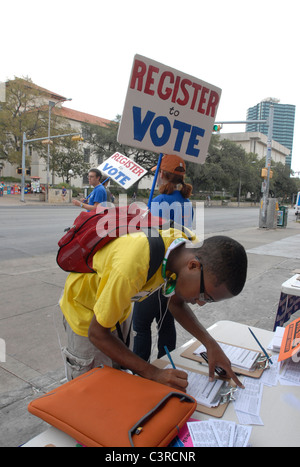 Étudiant afro-américain remplit remplit la paperasse pour s'inscrire pour voter comme d'autres sont des signes d'encourager à s'inscrire Banque D'Images