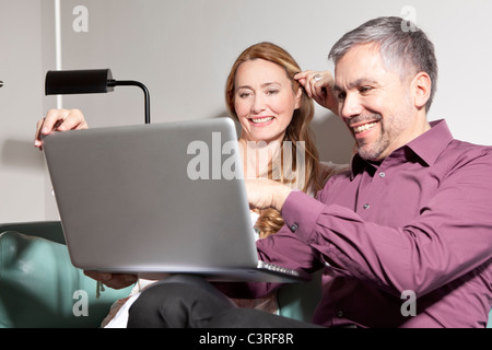 L'homme et de la femme d'âge moyen à l'aide d'ordinateur portable Banque D'Images