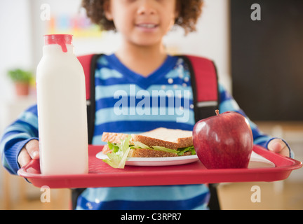 African American school girl holding le déjeuner sur un plateau Banque D'Images