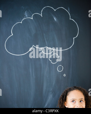 African American girl, debout près de bulle pensée on blackboard Banque D'Images