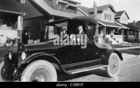 Un homme regarde à partir d'un coupé 1920 voiture. voiture vintage 20s à la mode antique maisons Banque D'Images