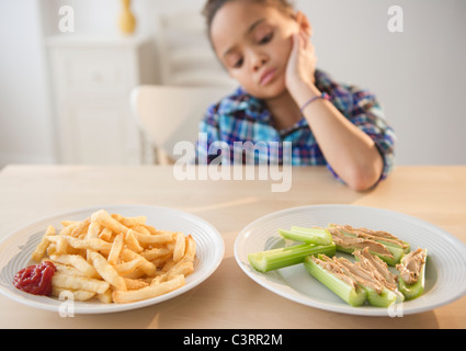 African American girl looking at aliments sains et malsains Banque D'Images