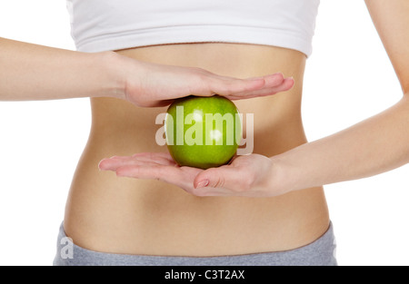 Close-up of female hands holding an apple in front of belly Banque D'Images