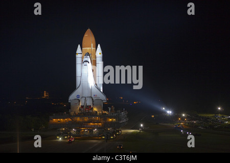 Finale de l'entreprise Roll baigné de feux au xénon, la navette spatiale Endeavour se déplace le long de la crawlerway du bâtiment d'assemblage de véhicules de lancement 39A au Centre spatial Kennedy en Floride. Équitation au sommet d'un crawler-transporter attaché à son réservoir de carburant externe et propulseurs, tenter sa dernière 3,4 milles au pad, connu sous le nom de "mise en place," a pris un peu moins de huit heures. Image Crédit : NASA/Terry Zaperach 11 Mars, 2011 Banque D'Images