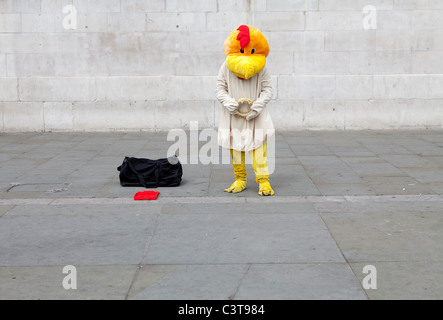 Un interprète dans un costume d'oiseau fait une triste poser contre un fond uni Banque D'Images