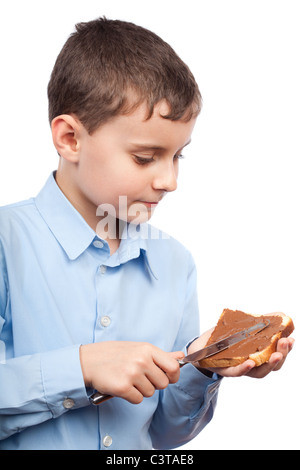 Closeup portrait of a Boy diffusion de chocolat ou de beurre d'arachide sur tranche de pain Banque D'Images