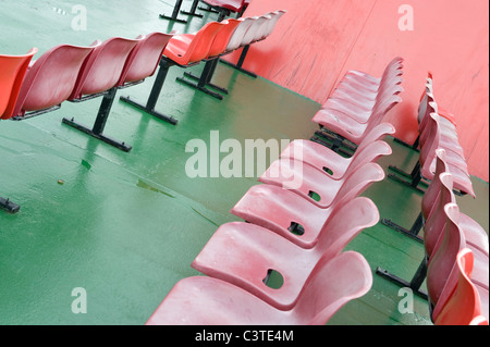 Des rangées de fauteuils rouges sur le pont d'un ferry. Banque D'Images