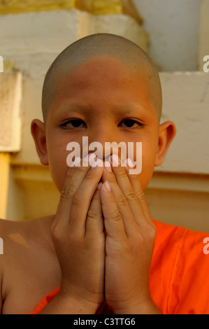 Jeune novice faisant les trois singes de la sagesse proverbiale, principe au cours de cérémonie d'ordination ,Wat Santithammaram,Bangkok, Thaïlande Banque D'Images