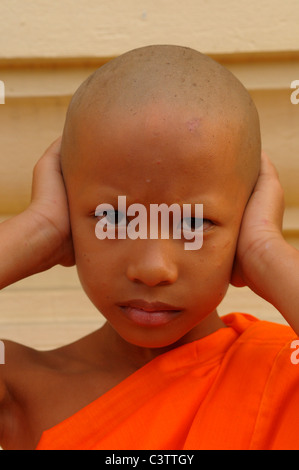 Jeune novice faisant les trois singes de la sagesse proverbiale, principe au cours de cérémonie d'ordination ,Wat Santithammaram,Bangkok, Thaïlande Banque D'Images