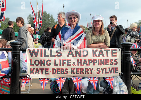 Mariage Royal fans avec leur bannière à l'extérieur de Buckingham Palace la nuit avant le mariage royal, avril 2011. Banque D'Images