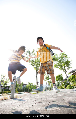 Les garçons de l'école élémentaire le saut, low angle view, Japon Banque D'Images