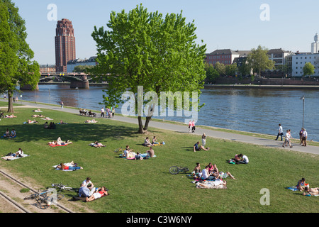 Les gens se détendre au bord de la rivière Main à Francfort, Allemagne sur une journée de la fin du printemps. Banque D'Images