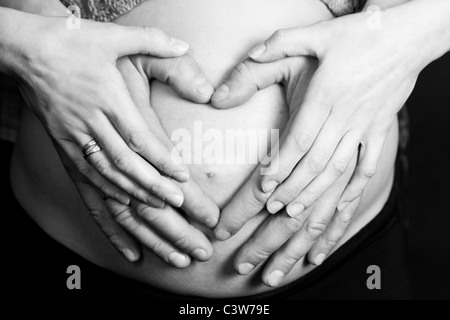 Pregnant belly et forme de coeur créé par hands