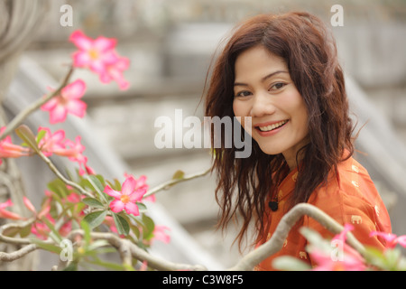 Portrait of beautiful smiling woman avec des fleurs tropicales Banque D'Images
