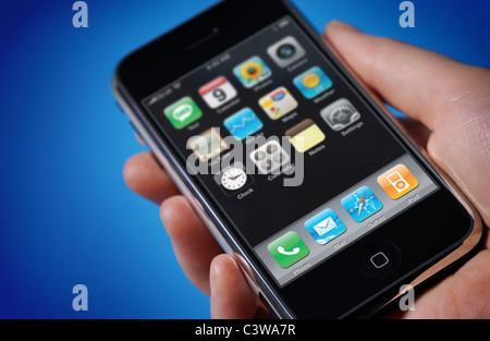 Vue sur un iPhone dans une main masculine sur un fond bleu Banque D'Images