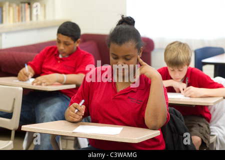 Hispaniques et Afro-américaines d'Anglo, garçons et filles prendre quiz à leur bureau pendant les cours à l'Académie Rapoport Banque D'Images