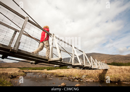Un pont suspendu au-dessus de l'hôtel nam Beathach dans Glen Orchy, Écosse, Royaume-Uni, à la recherche jusqu'à l'Munro d'un Odhair Stob Dromore West. Banque D'Images