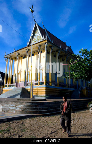 Un homme cambodgien aveugle est passé à pied un beau temple bouddhiste à Kratie, au Cambodge. Banque D'Images