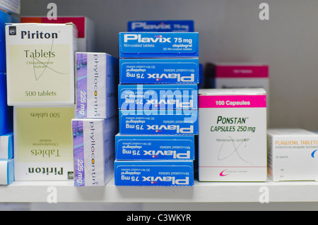 Pile de Plavix (clopidogrel) comprimés sur une étagère, à côté de la pharmacie, Piriton Phyllocontin, Pontal et Plaquenil. Banque D'Images