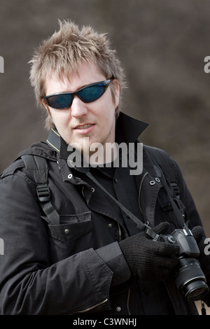 Portrait of a young man holding a camera Banque D'Images