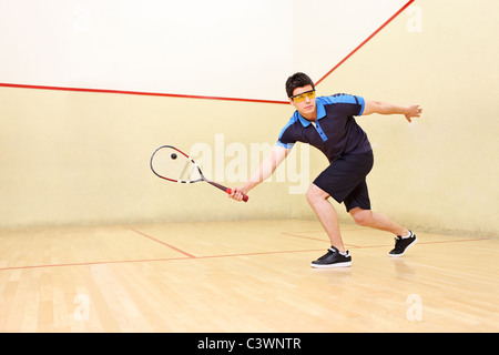 Un joueur de frapper une balle de squash Banque D'Images